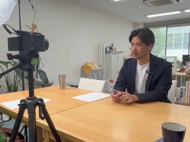 カメラを据えてインタビューを撮影しているところ